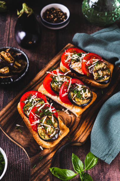 istock Vegetarian bruschetta with grilled eggplant, tomatoes and cheese on a board vertical view 2170829718