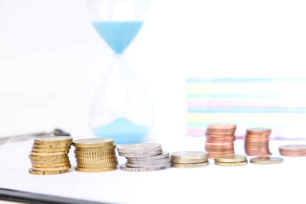 Money, coins and hourglass. Selective focus.