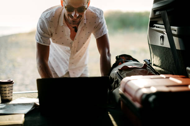 istock Man sits in a trunk and uses a laptop 2170832202