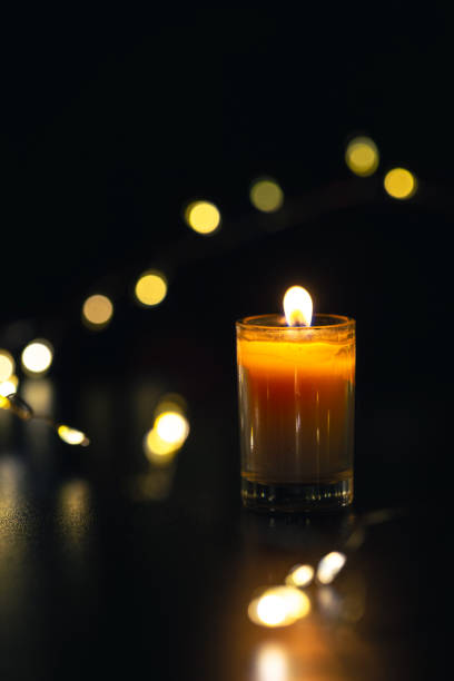 istock Burning candle on black background with bokeh. Memorial Day. 2170832952