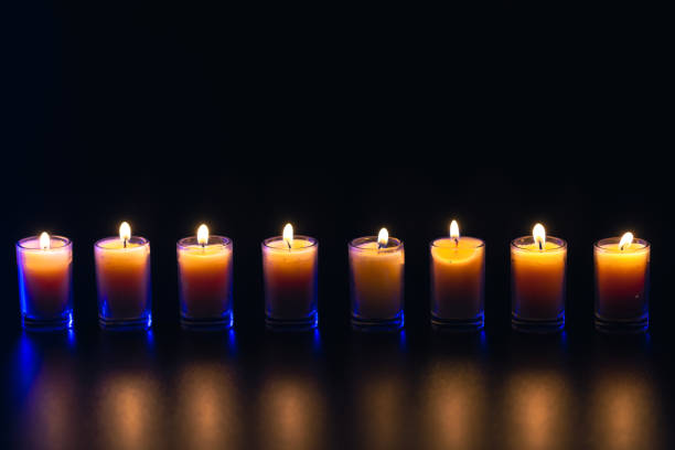 istock Burning candle on black background with backlight. Memorial Day. 2170832954