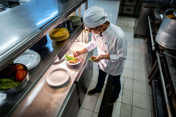 istock Head chef finishing to prepare a dish in a commercial kitchen 2170834731