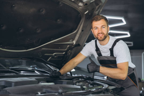 istock Smiling Mechanic Giving Thumbs Up While Working on Car Engine in Auto Repair Shop 2170835334