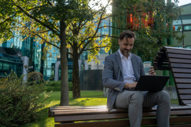 Modern man working on a laptop at the park