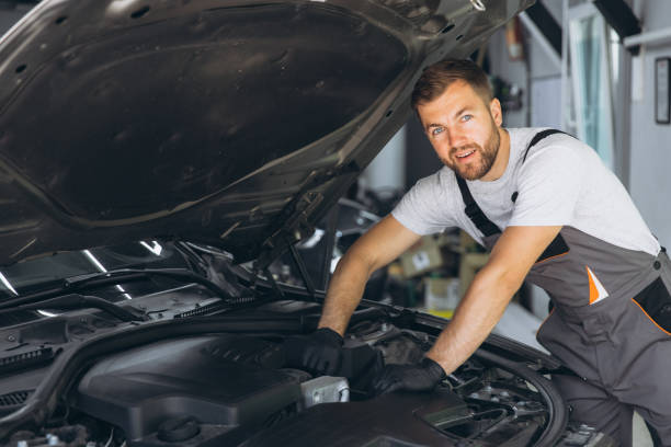 istock Smiling Auto Mechanic in Overalls Working on Car Engine in Garage 2170835892