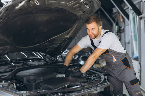 istock Smiling Auto Mechanic in Overalls Working on Car Engine in Garage 2170835895