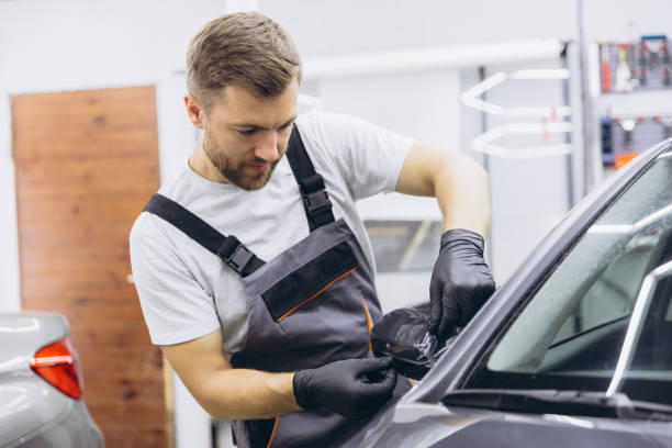 istock Professional Auto Mechanic Applying Protective Film to Car Mirror in Workshop 2170836827