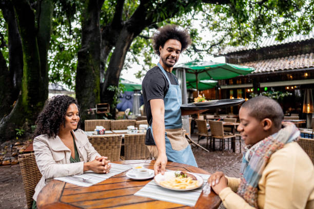 istock Young waiter serving foods to customers at restaurant 2170837751