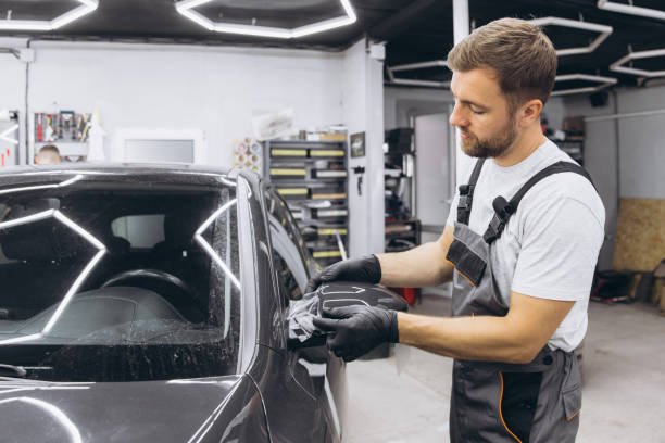istock Professional Auto Mechanic Applying Protective Film to Car Mirror in Workshop 2170837902