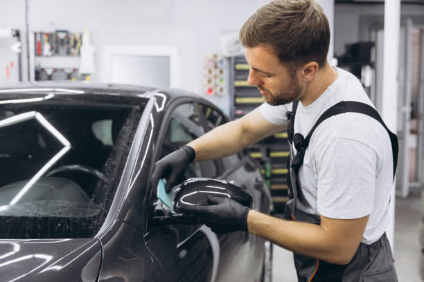 istock Professional Auto Mechanic Applying Protective Film to Car Mirror in Workshop 2170837903