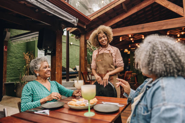 istock Waitress talking with customers at restaurant 2170840261