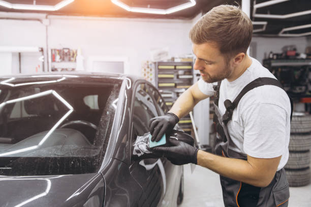 istock Professional Auto Mechanic Applying Protective Film to Car Mirror in Workshop 2170840377