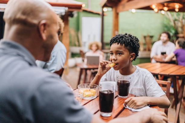 istock Son eating and talking with father at restaurant 2170841507