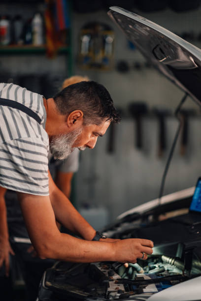 istock Colleagues technicians examining and fixing car problem at mechanic shop 2170844611
