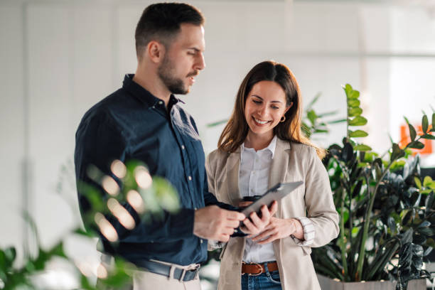 istock Innovative businesspeople with tablet discussing report at workspace. 2170844645