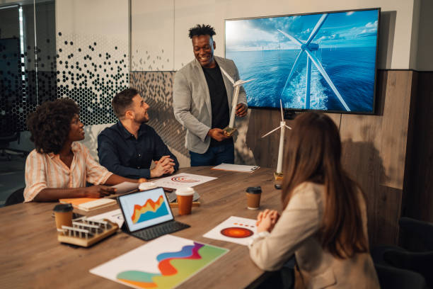 istock Diverse ecology expert presenting windmill model to investors at office 2170844657