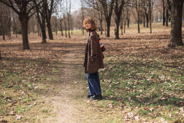 Redhead curly woman in park.
