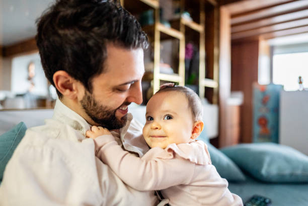 istock Father with daughter on his lap at home 2170847292