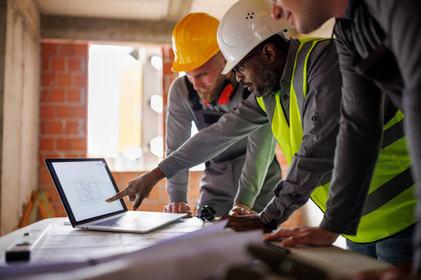 Engineer and construction worker discussing the blueprint project at the construction site