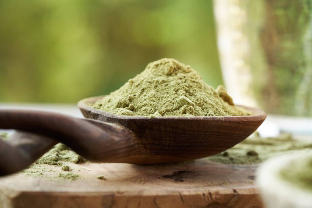 istock Barley grass powder on a wooden spoon outdoors in nature 2170850974