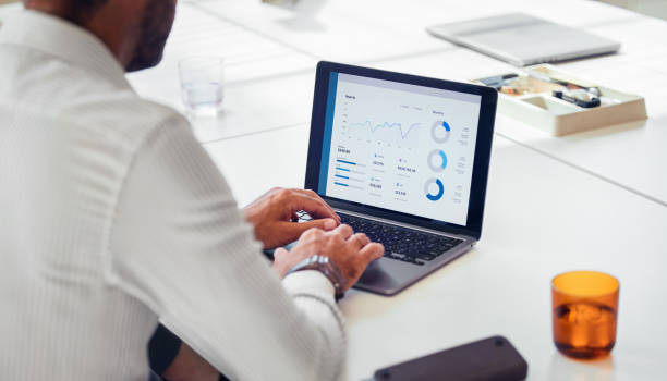 Businessman Analyzing Financial Data on Laptop in Office