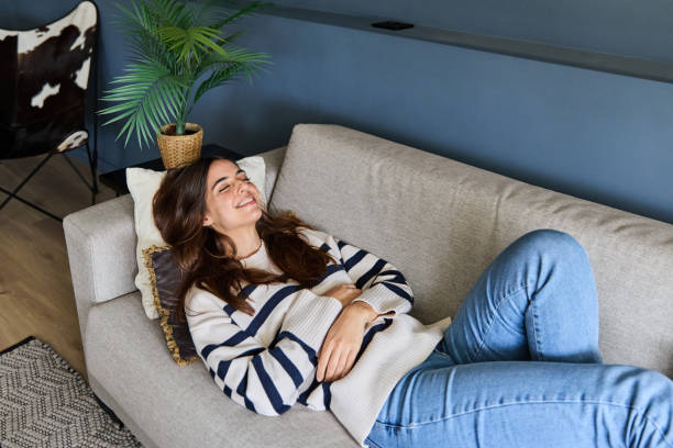 istock Beautiful woman is lying on a comfortable sofa with her eyes closed, enjoying a peaceful moment at home 2170863328