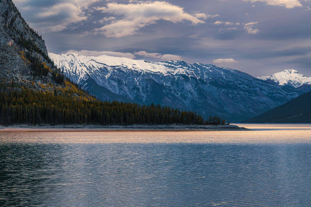 A panoramic cloudy sky over mountains at Lake Minnewanka.