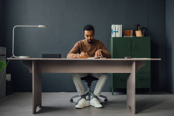 istock Focused Professional Man Writing at Modern Office Desk 2170879153