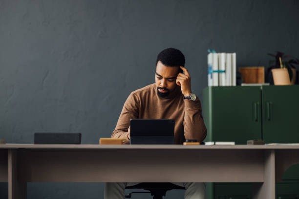 istock Thoughtful Businessman Working on Tablet in Modern Office 2170879159