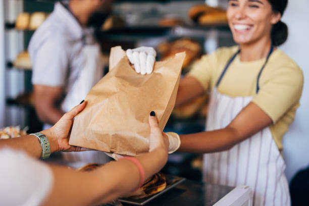 istock Friendly Baker Handing a Paper Bag to Customer 2170880555