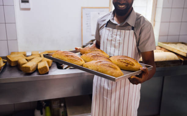 Baker Presenting Freshly Baked Homemade Bread in Kitchen