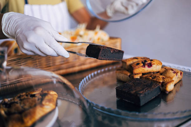 istock Gloved Hands Serving Freshly Baked Brownies and Pastries 2170880597