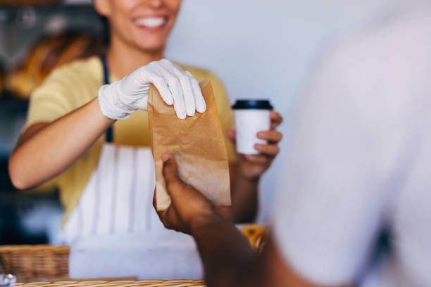 istock Smiling Barista Serving Customers in a Coffee Shop 2170880642