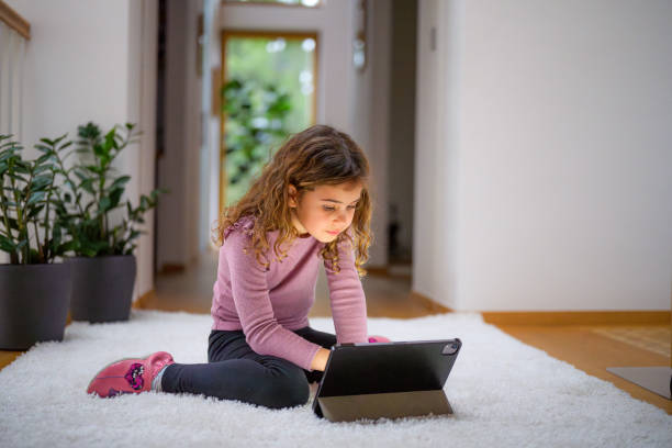 Young Girl Engrossed in Tablet Usage Indoors