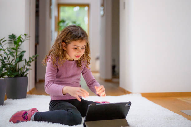istock Young Girl Engrossed in Tablet Technology Indoors 2170885212