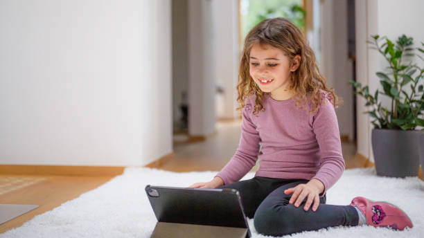 istock Smiling Girl Engages with Tablet on Cozy Floor 2170885287
