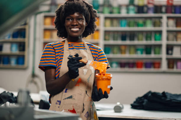 istock Smiling diverse graphic worker preparing ink for silkscreen printing. 2170887441
