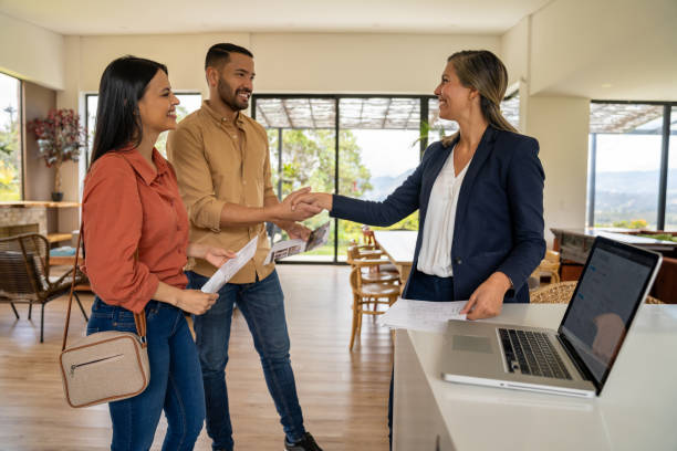 istock Real estate agent greeting clients with a handshake at a house showing 2170888048