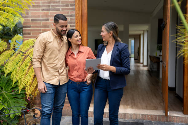 istock Couple talking to a real estate agent while looking at a house 2170888051