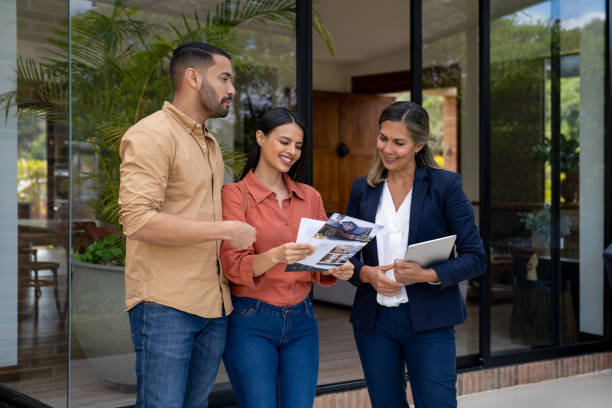 istock Couple talking to a real estate agent while looking at a house 2170888061