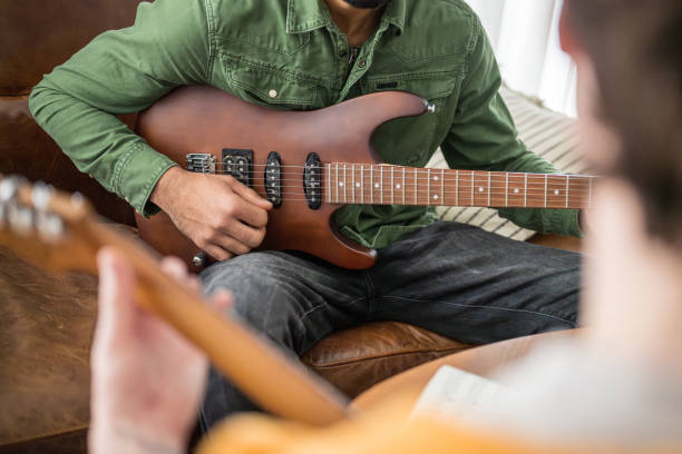istock Guitar Lesson in Progress with Caucasian Instructor and Black Student 2170888483