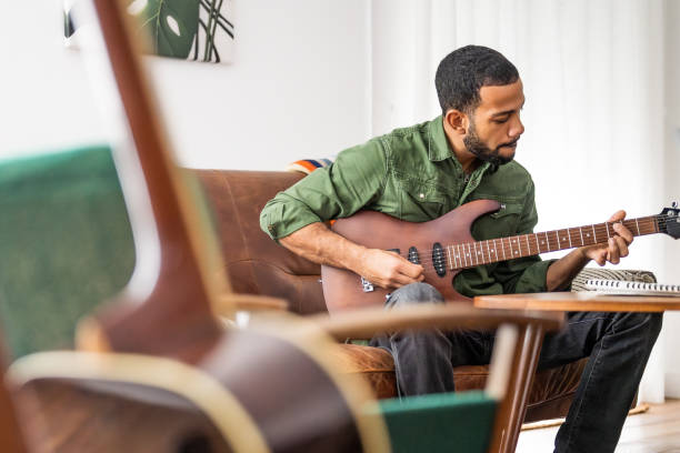 Focused Guitarist Engages with Music at Home