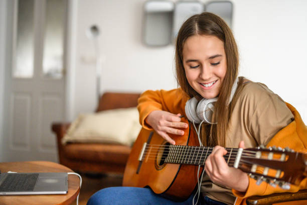 istock Caucasian Woman Practices Guitar Indoors 2170888515
