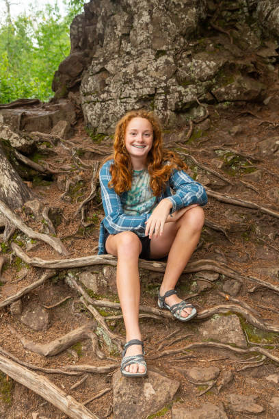 Girl Sitting On Exposed Roots in Woods