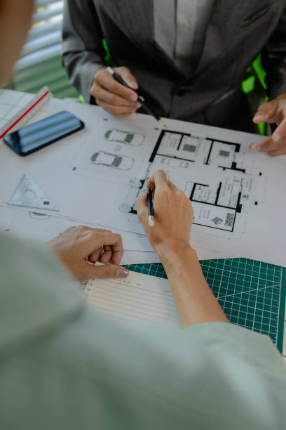istock engineers are sitting discussing a construction plan that needs to be revised to make the structure stronger, an architect and assistant are brainstorming and examining the blueprints 2170894934