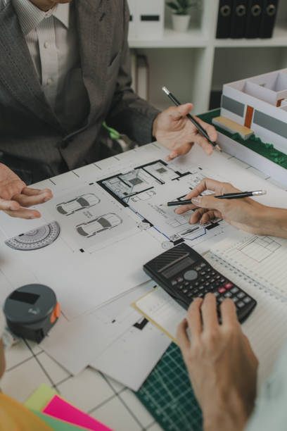 istock an architect and his assistant are brainstorming and examining the blueprints, two engineers are discussing a construction plan to make the structure stronger, draft, meeting, teamwork 2170894950