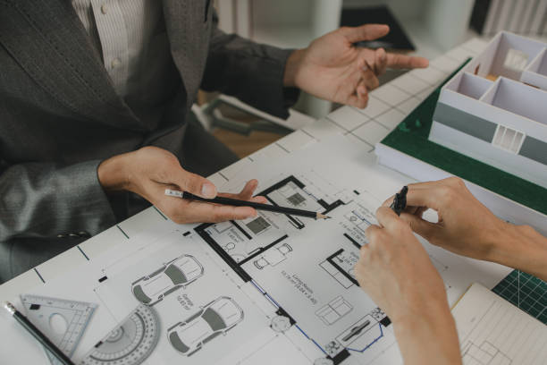 istock engineers are sitting discussing a construction plan that needs to be revised to make the structure stronger, an architect and assistant are brainstorming and examining the blueprints 2170894966