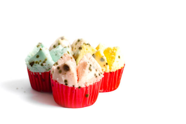Isolated spoiled Thai dessert, 'Pui Fai', is covered with black and colored mold, making it unsafe to eat on white background.