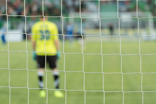 Goalkeeper defending goal in soccer game on an indoor court