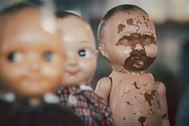 Old dolls with damage and spooky scary missing face. Abandoned and forgotten toy in horrer halloween concept.